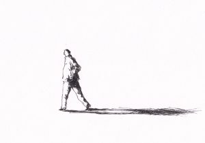 Person geht nach rechts und wirft einen langen Schatten